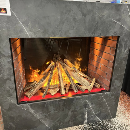 Close-up studio product photo of the built-in electric fireplace insert framed in dark marble-look surround, showing the log set and orange flame effect in detail.