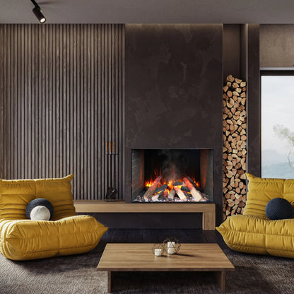 A built-in electric fireplace with orange flames set into a dark wood-paneled wall beside a vertical firewood storage slot, in a moody living room with mustard yellow cushions and navy accent pillows on a gray sofa.