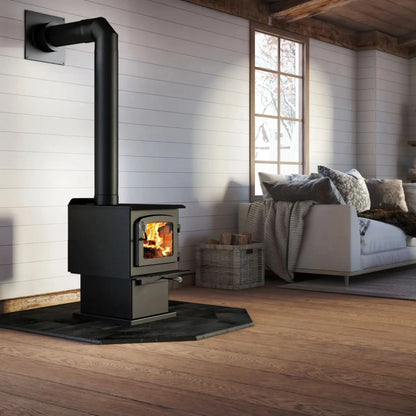 Drolet Escape 1200 N pedestal wood stove in a living room with black stove pipe and slate hearth pad