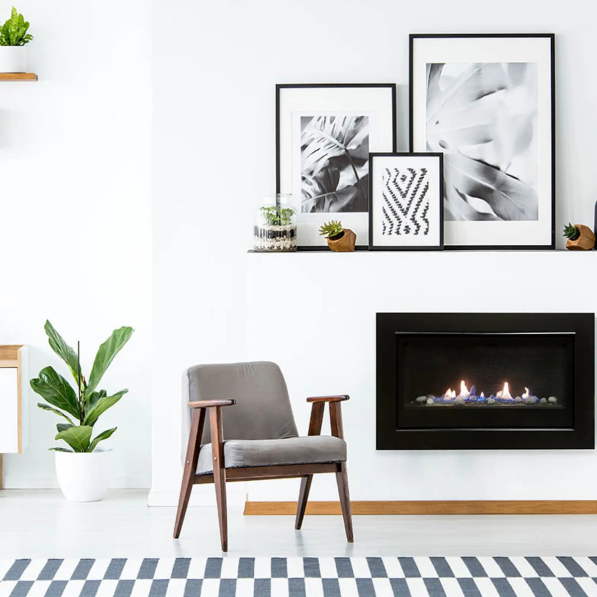 Sierra Flame Boston 36 linear gas fireplace on a white wall beside an armchair and plants