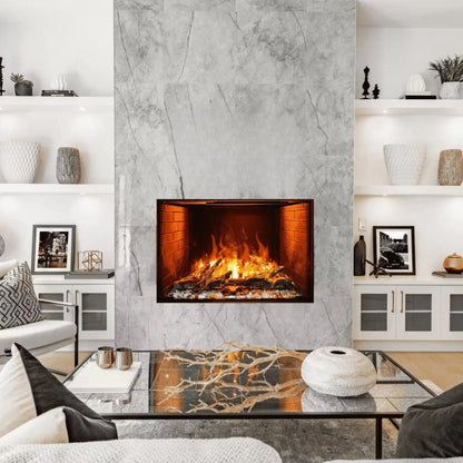 A built-in electric fireplace with orange flames set into a gray marble-tiled wall, flanked by white built-in cabinets with glass doors, above a glass coffee table styled with a branch centerpiece and a round ceramic vase.
