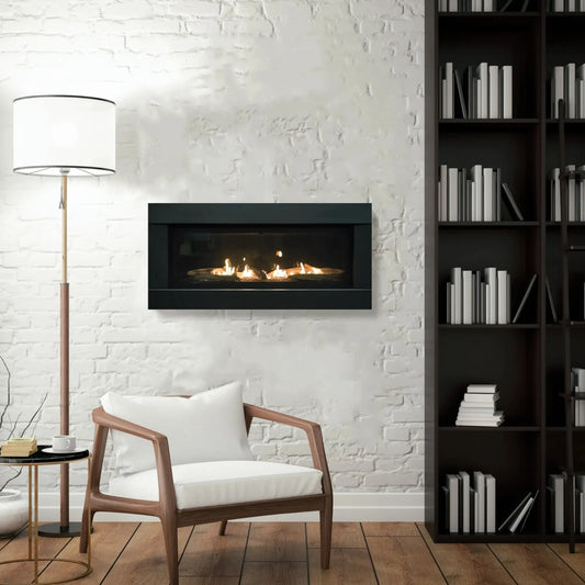 Sierra Flame Stanford 55 linear gas fireplace on a white brick wall beside a bookcase and armchair