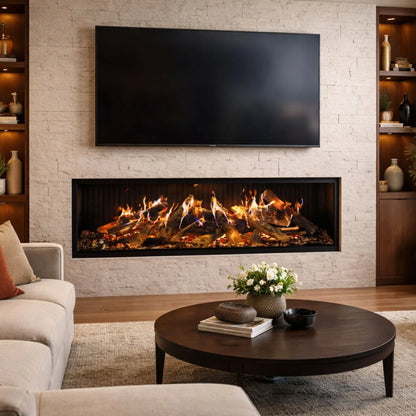 A 3-sided linear electric fireplace with a glowing log set built into a white stacked-stone wall beneath a mounted flat-screen TV, flanked by wood built-in shelving with vases and books, in a bright modern living room with a round coffee table.