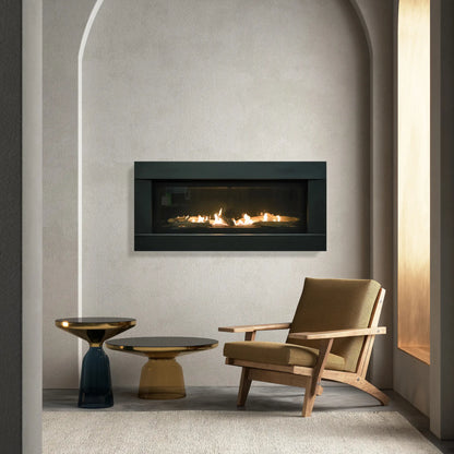 Sierra Flame Stanford modern linear gas fireplace in an arched alcove next to a lounge chair